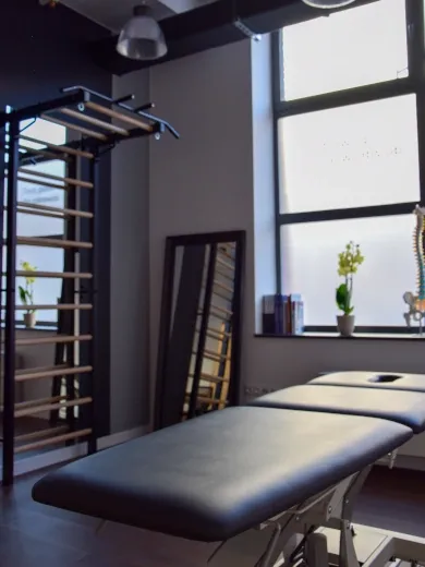 Gabinet fizjoterapii z profesjonalną leżanką, drabinką rehabilitacyjną i lustrem do kontroli postawy